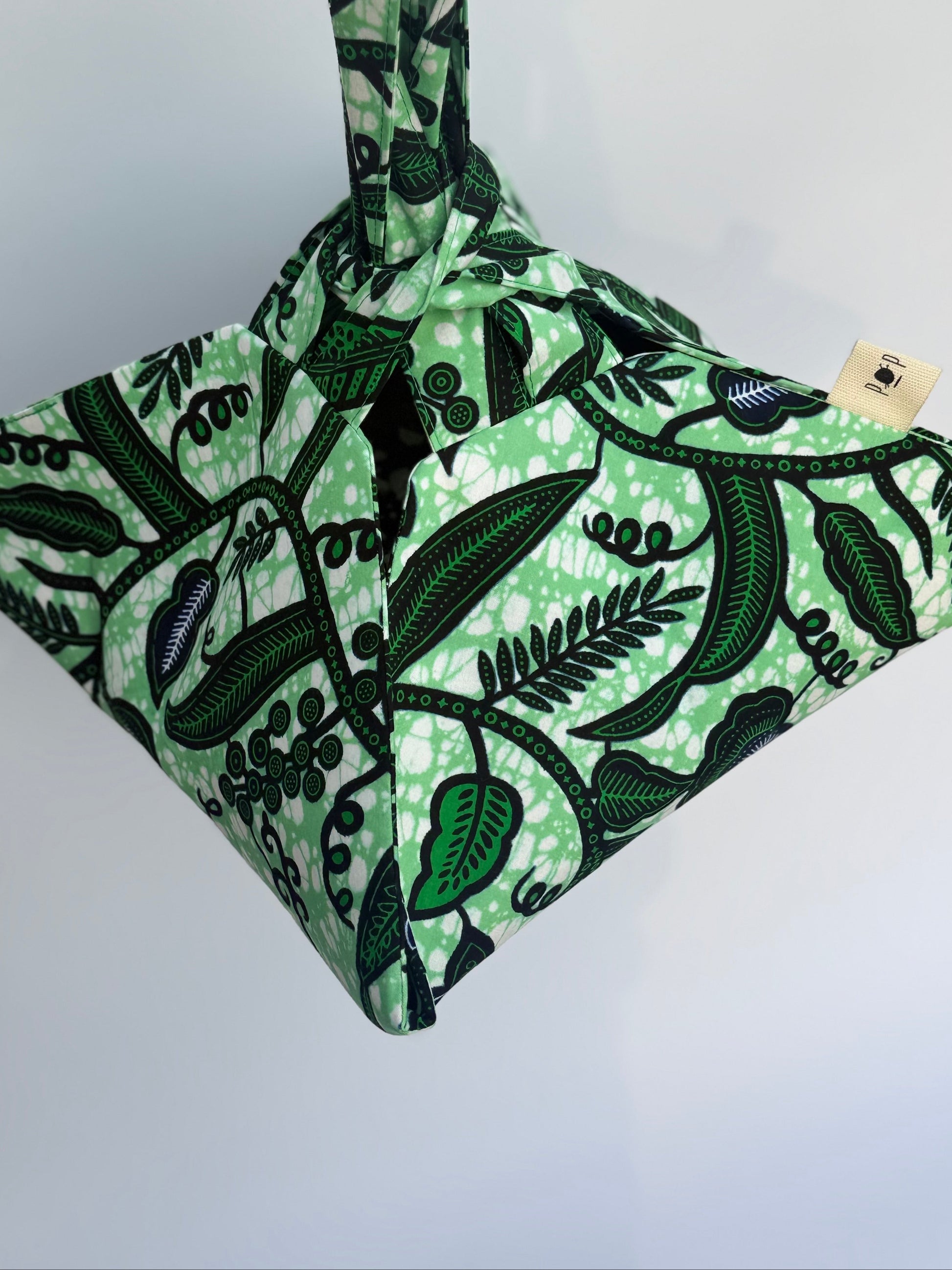 Green and black patterned bag with a visible brand label on a white background